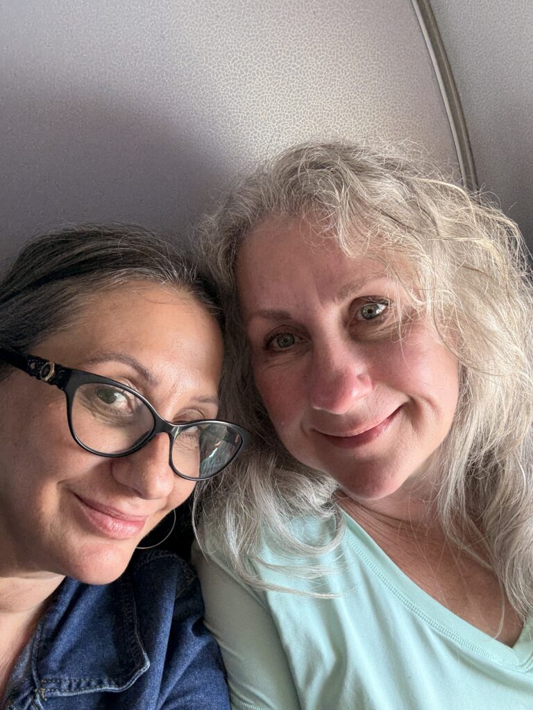 Selfie of Lisa and Cora on the plane, smiling as they land in New York City