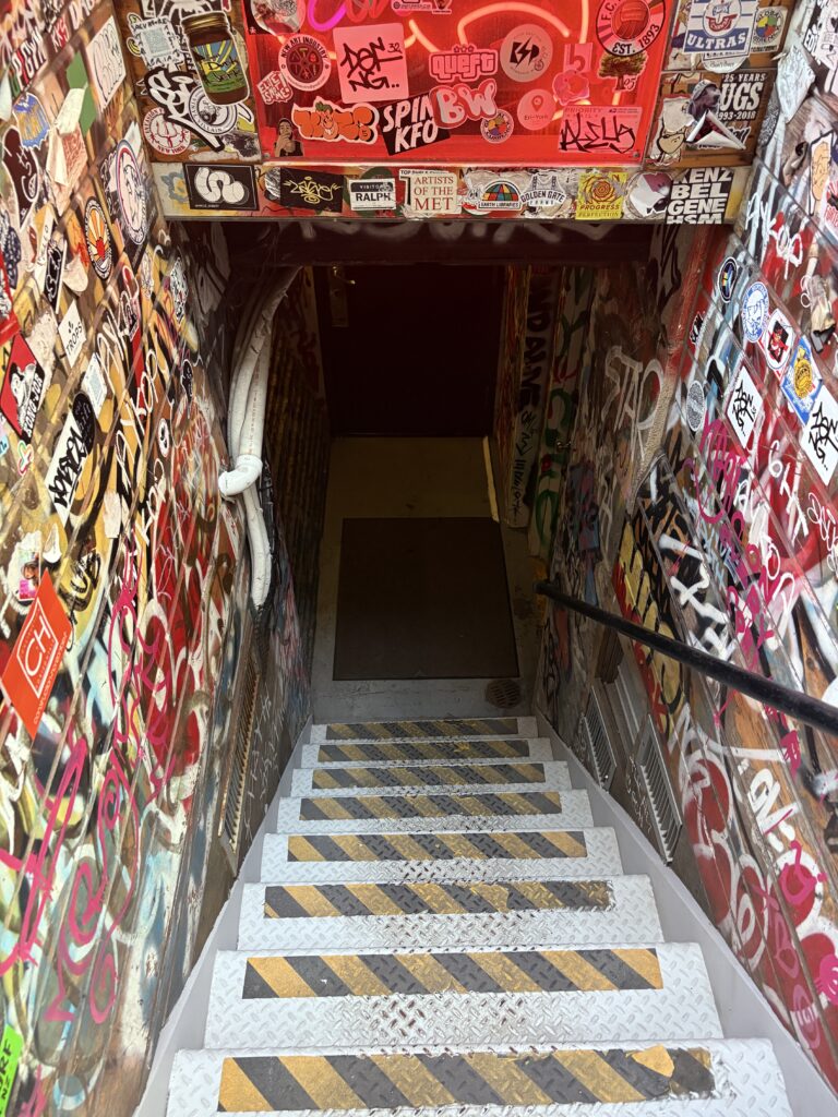 Graffiti-covered staircase in New York City, filled with stickers and street art