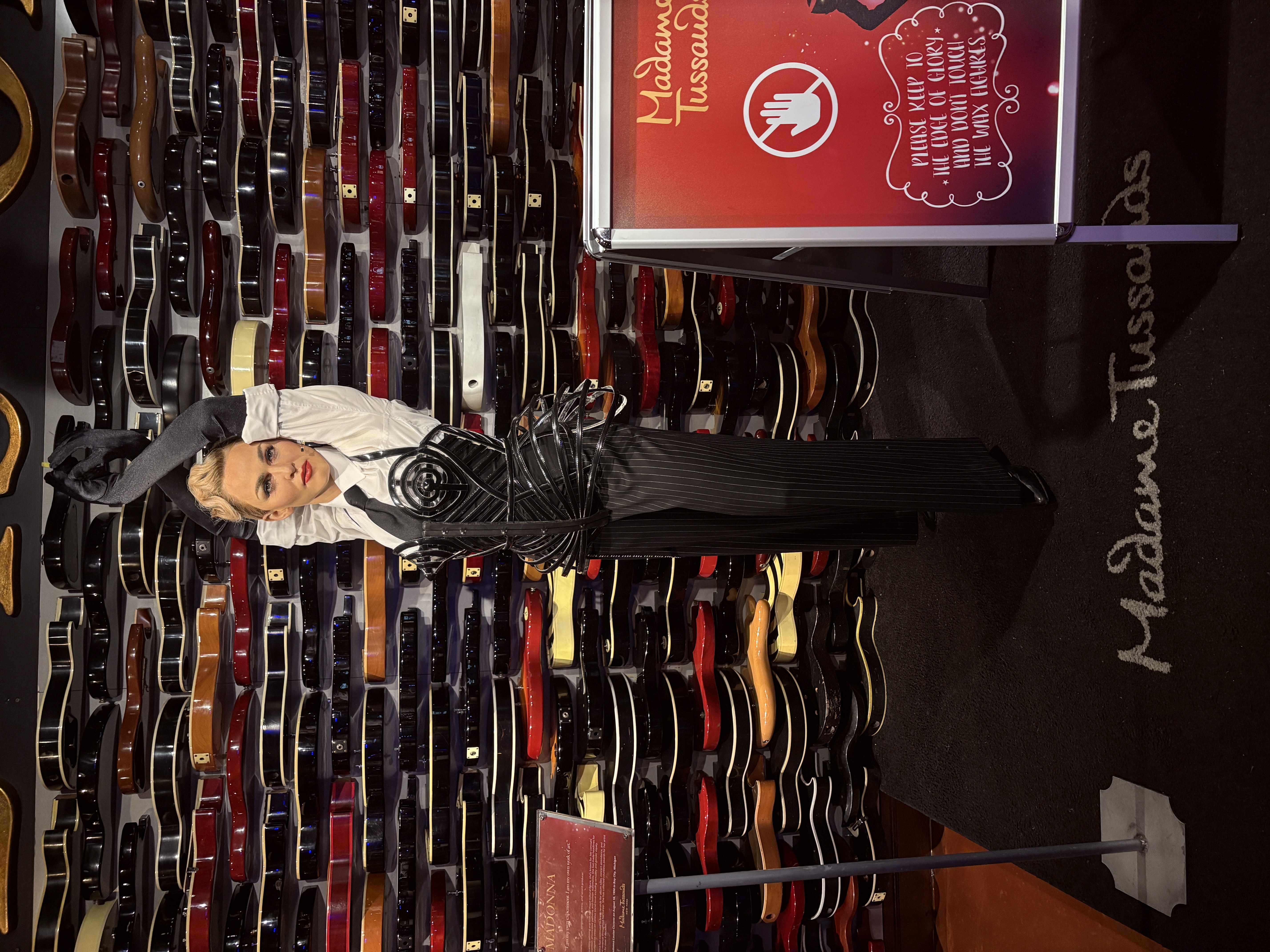 Wax figure of Madonna at Madame Tussauds, standing in front of a wall of guitars inside the Hard Rock Café in New York City.