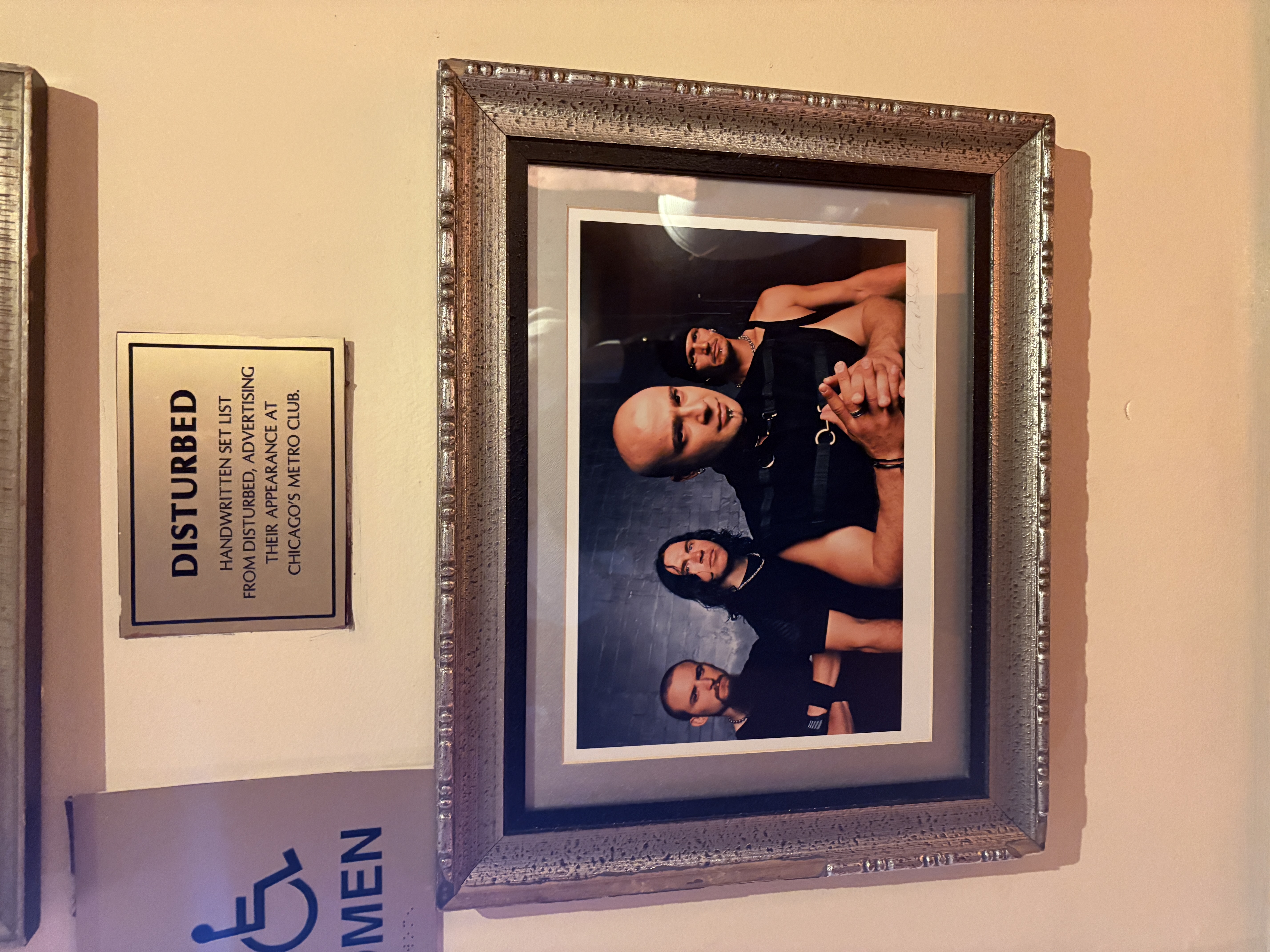 Framed photo and plaque of the rock band Disturbed on display at the Hard Rock Café in New York City.