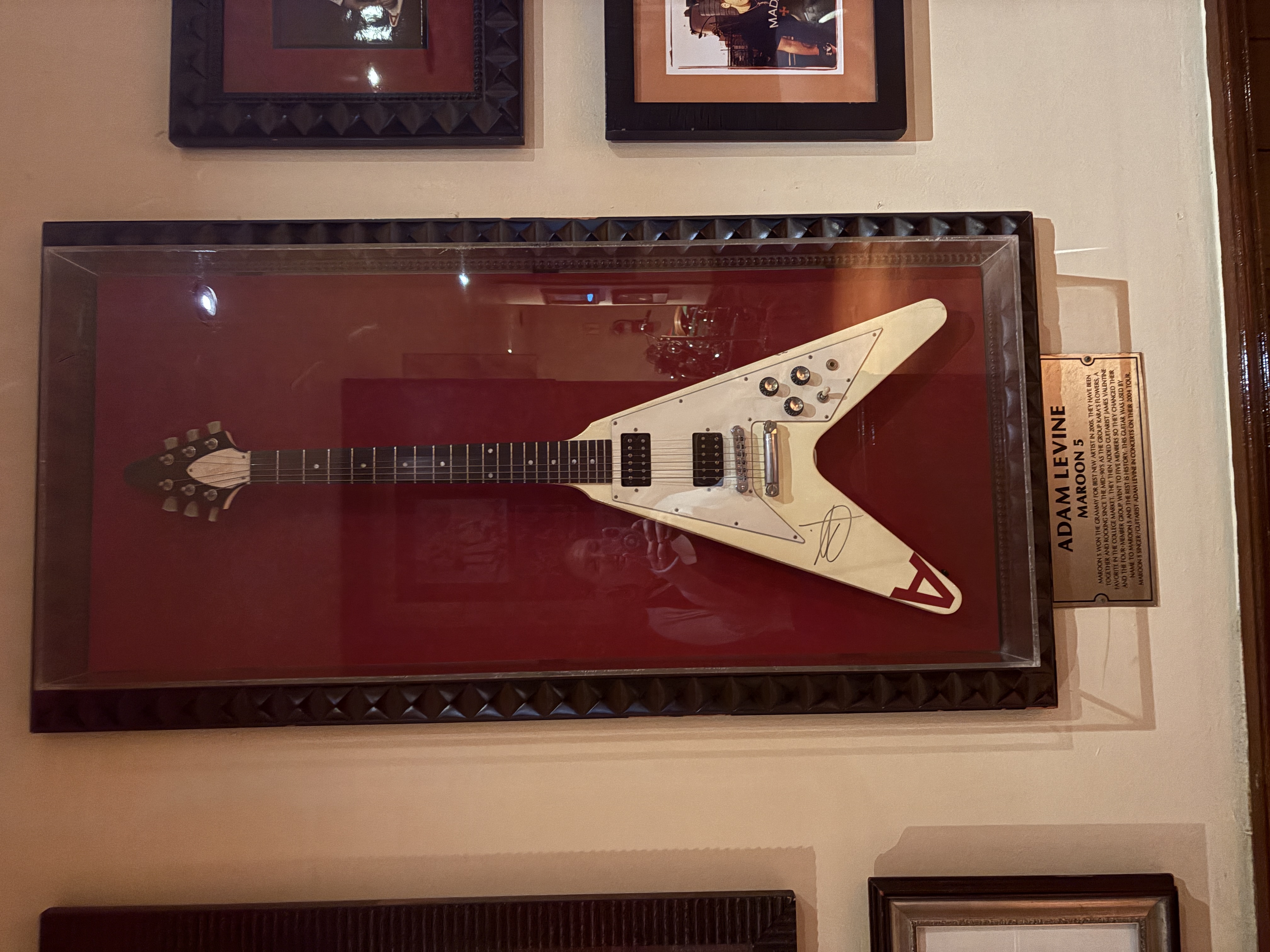 Signed guitar from Adam Levine of Maroon 5 displayed in a frame at the Hard Rock Café in New York City.