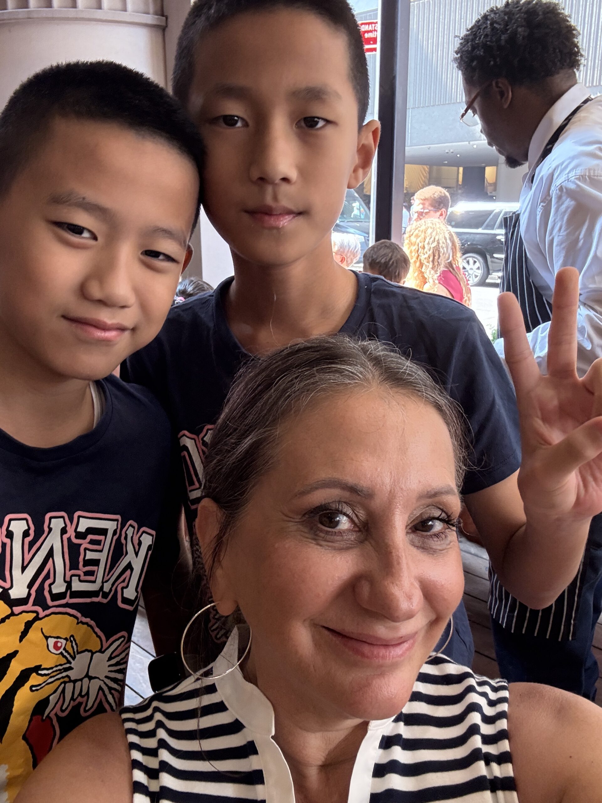Lisa smiling with William and Victor at Junior’s restaurant in New York.